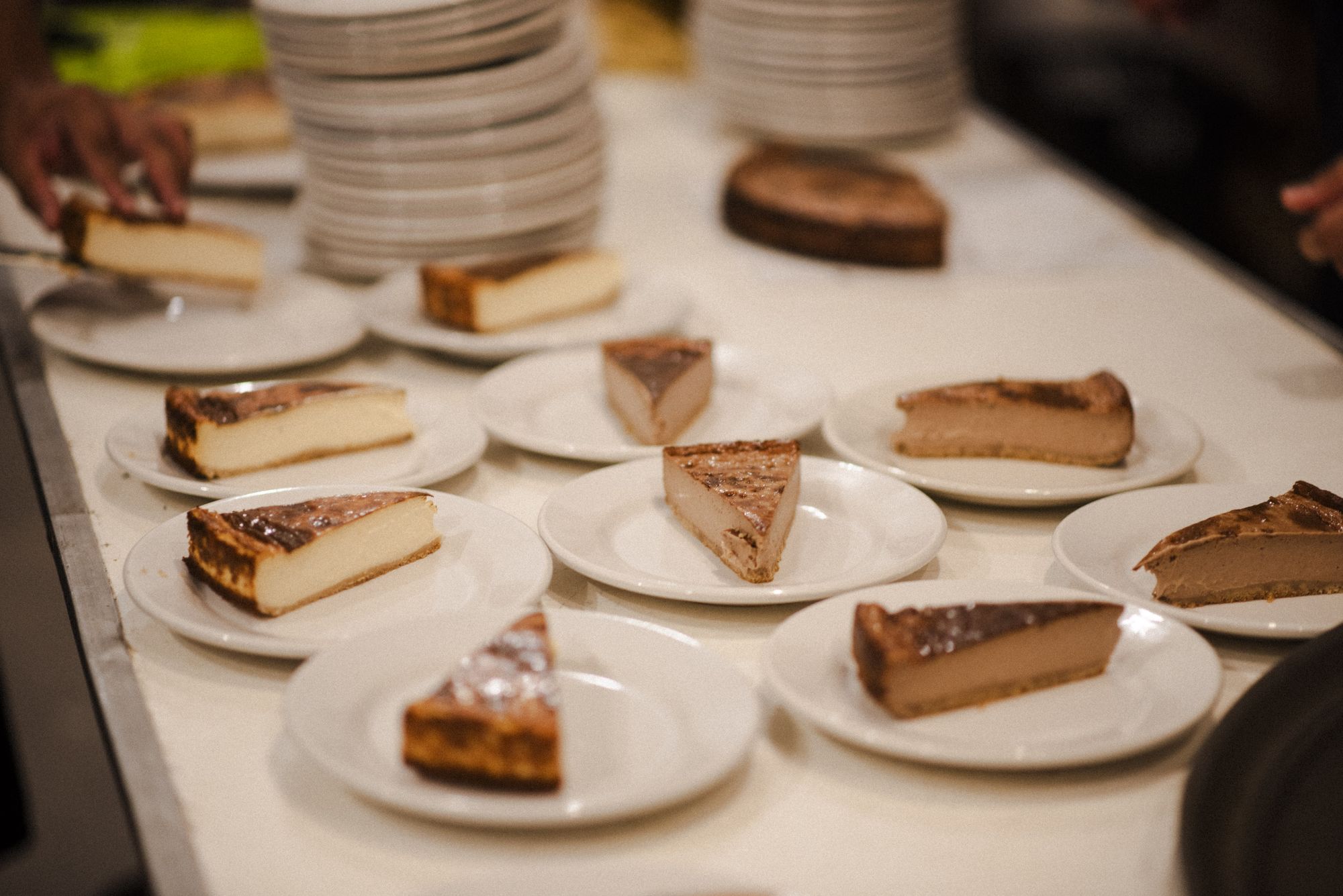 Rebanadas de gazta tarta AUPA original y de chocolate emplatadas en barra antes de salir a las mesas de una boda