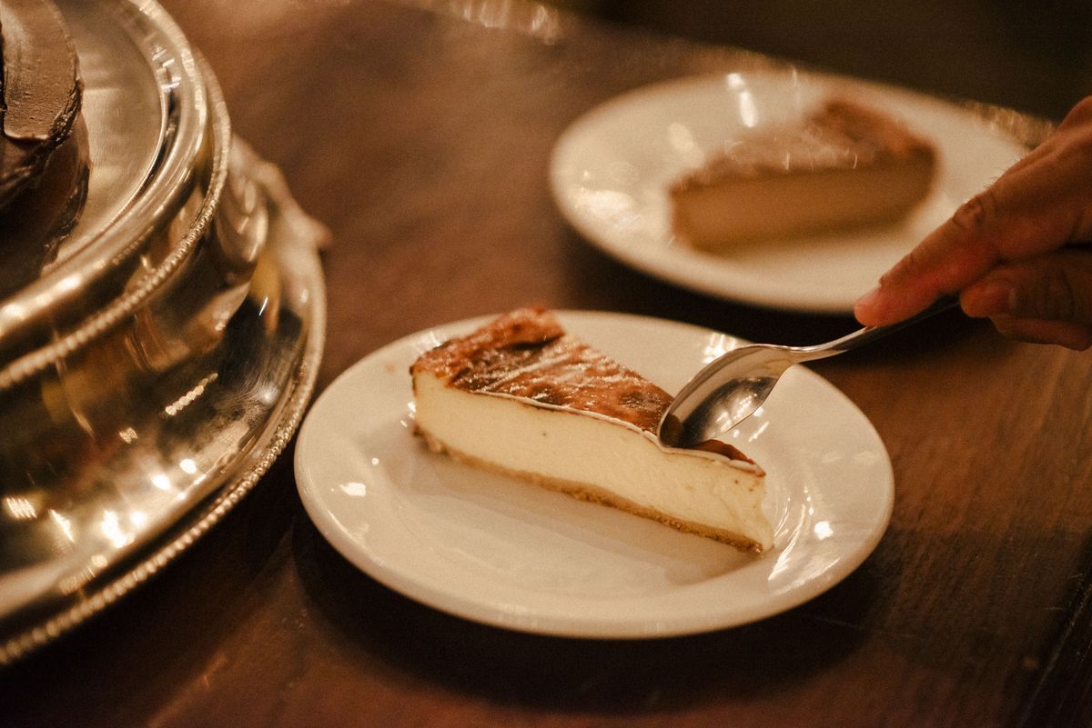 Rebanada de gazta tarta AUPA original en la mesa de una boda, con una cuchara tomando el primer bocado