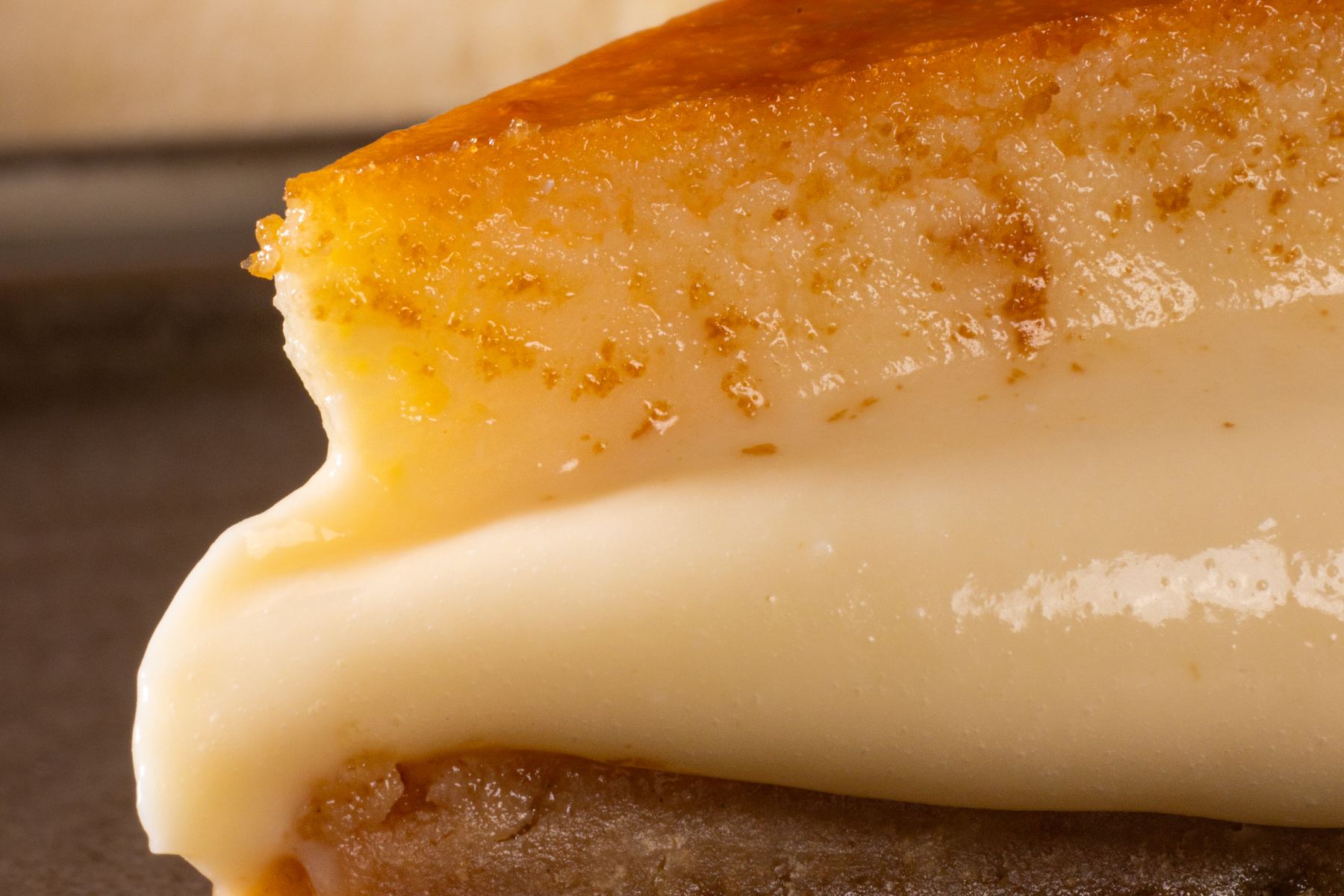 Corte de una rebanada de gazta tarta AUPA: superficie caramelizada arriba y centro cremoso