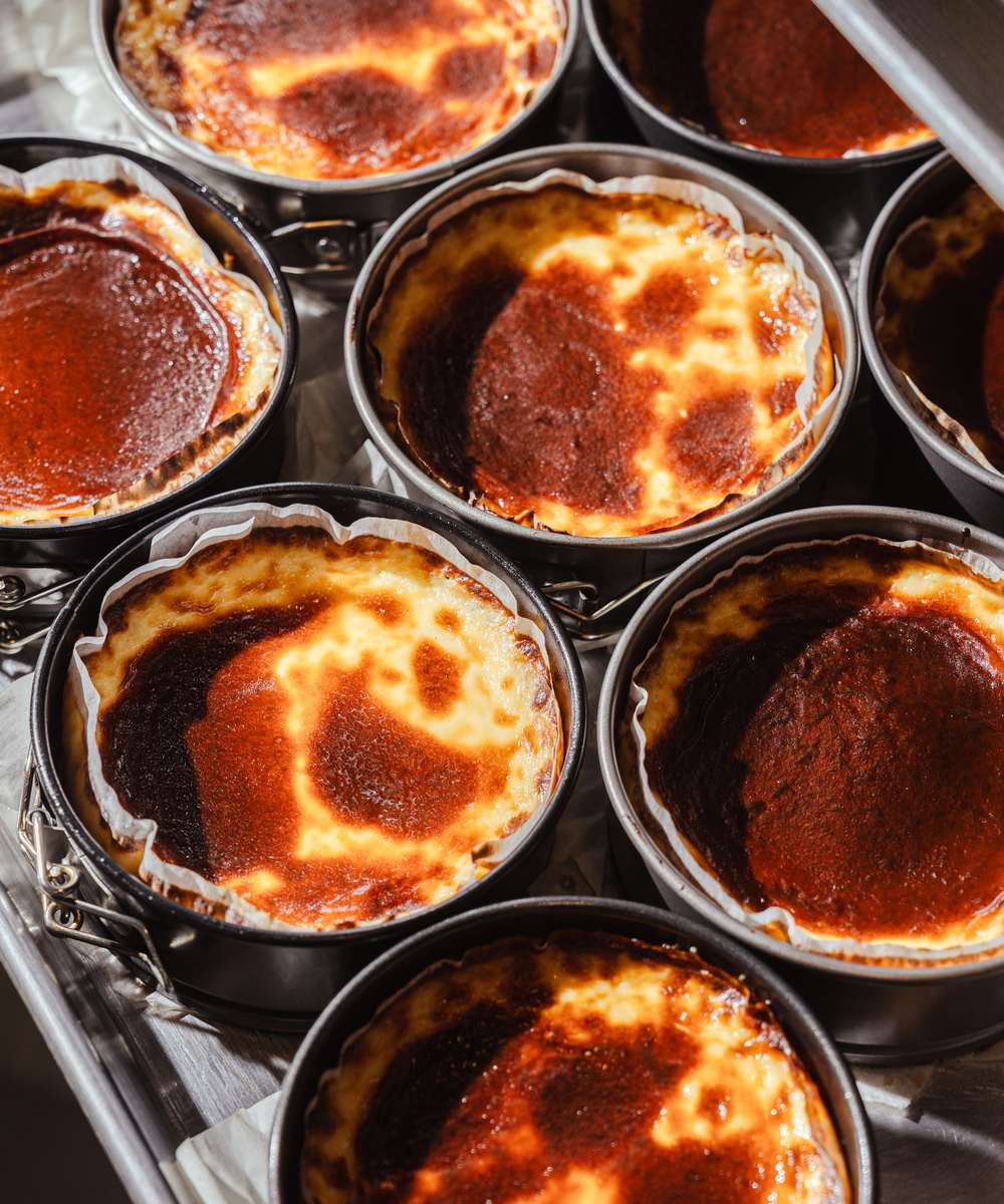 Charola con varias gazta tartas de AUPA recién salidas del horno en sus moldes
