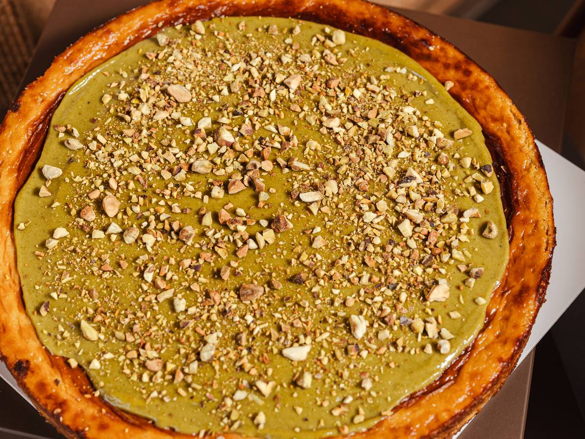 Tarta vasca de pistache de AUPA con cobertura de pistache y pistache troceado